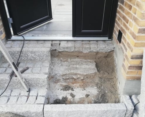 brostensarbejde ved indgang til hus